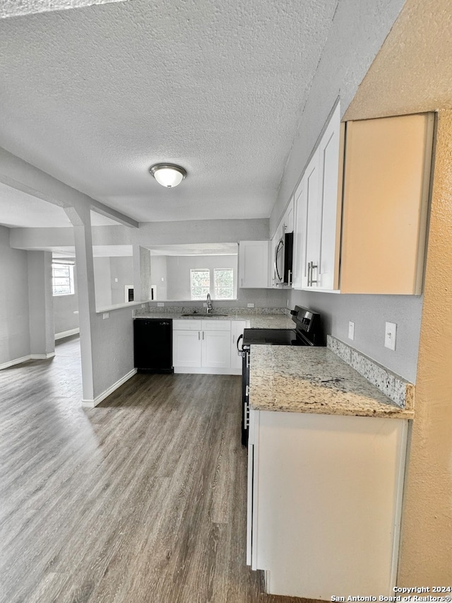 kitchen with plenty of natural light, black appliances, sink, and white cabinetry