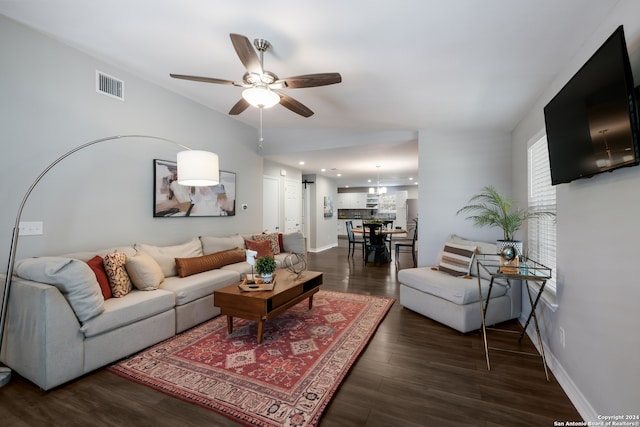 living room featuring ceiling fan and dark hardwood / wood-style floors