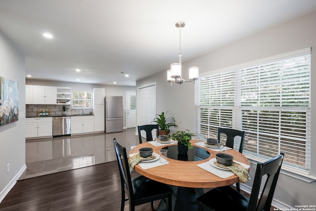 dining space featuring an inviting chandelier and dark hardwood / wood-style flooring