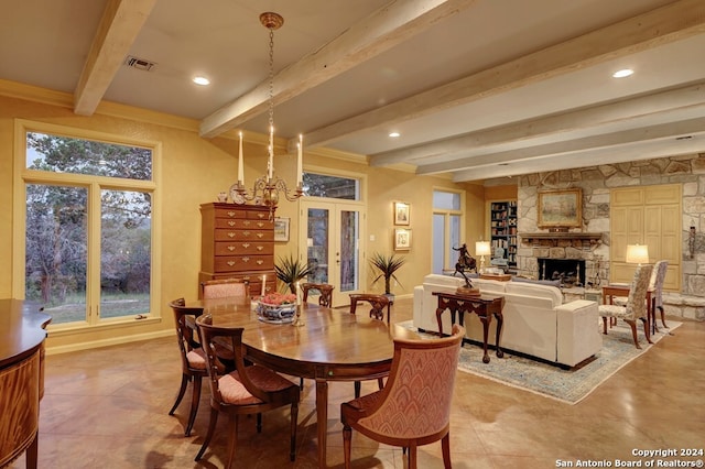 dining area with beam ceiling, a notable chandelier, and a stone fireplace