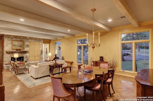 dining area with beam ceiling, a notable chandelier, and a stone fireplace