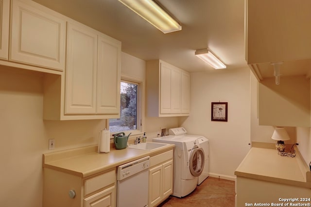 laundry area featuring cabinets, light tile patterned floors, independent washer and dryer, and sink