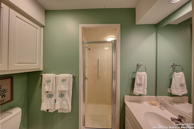 bathroom featuring vanity, toilet, and walk in shower