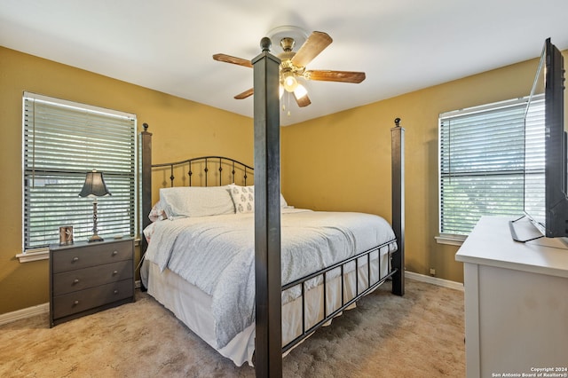 bedroom featuring multiple windows, ceiling fan, and light carpet