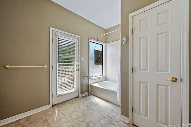 bathroom featuring tile patterned floors and a washtub