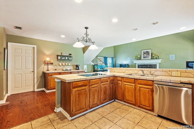 kitchen with decorative light fixtures, light hardwood / wood-style flooring, stainless steel dishwasher, kitchen peninsula, and sink