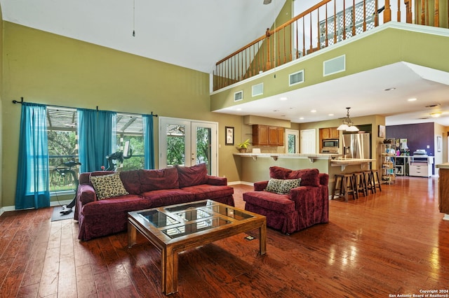 living room with hardwood / wood-style floors and a towering ceiling