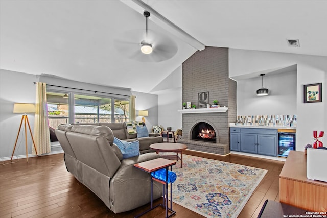 living room with a fireplace, wine cooler, ceiling fan, dark wood-type flooring, and indoor bar