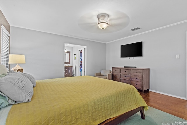 bedroom featuring crown molding, hardwood / wood-style floors, ensuite bathroom, and ceiling fan