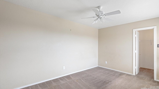 spare room featuring ceiling fan and carpet floors