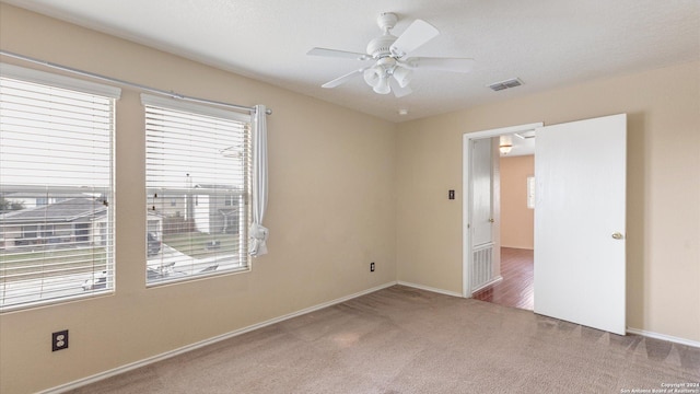 carpeted spare room featuring a textured ceiling and ceiling fan