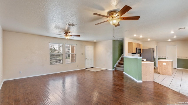 unfurnished living room featuring hardwood / wood-style floors, a textured ceiling, and ceiling fan