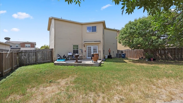 rear view of house featuring a patio area, a yard, and central AC