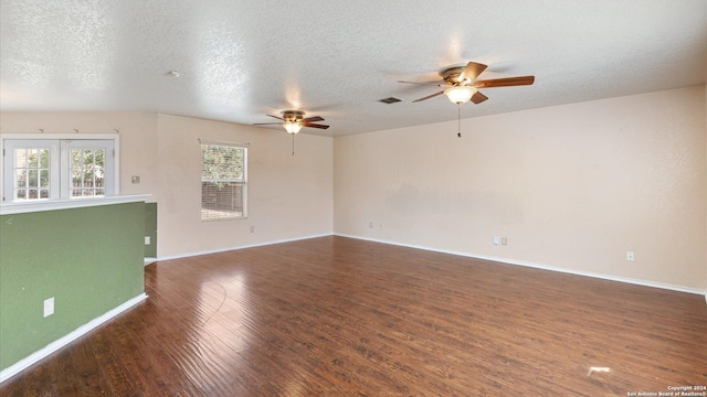 spare room featuring dark hardwood / wood-style floors, ceiling fan, and a textured ceiling