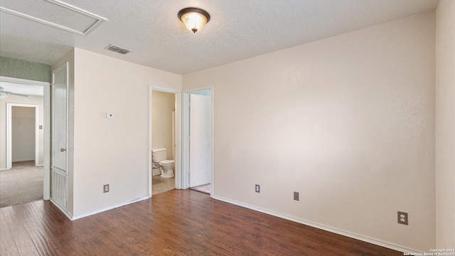 spare room with dark wood-type flooring and a textured ceiling