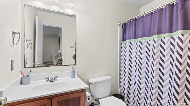 bathroom with a shower with shower curtain, vanity, and toilet