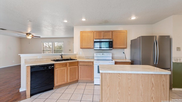 kitchen featuring a textured ceiling, a center island, sink, and stainless steel appliances