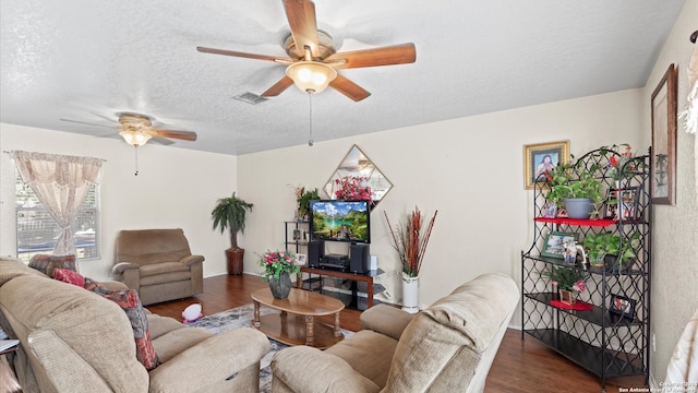 living room with ceiling fan, dark hardwood / wood-style flooring, and a textured ceiling