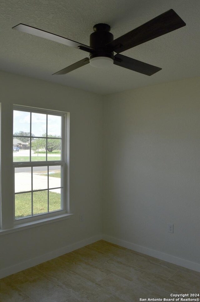 unfurnished room with a textured ceiling and ceiling fan