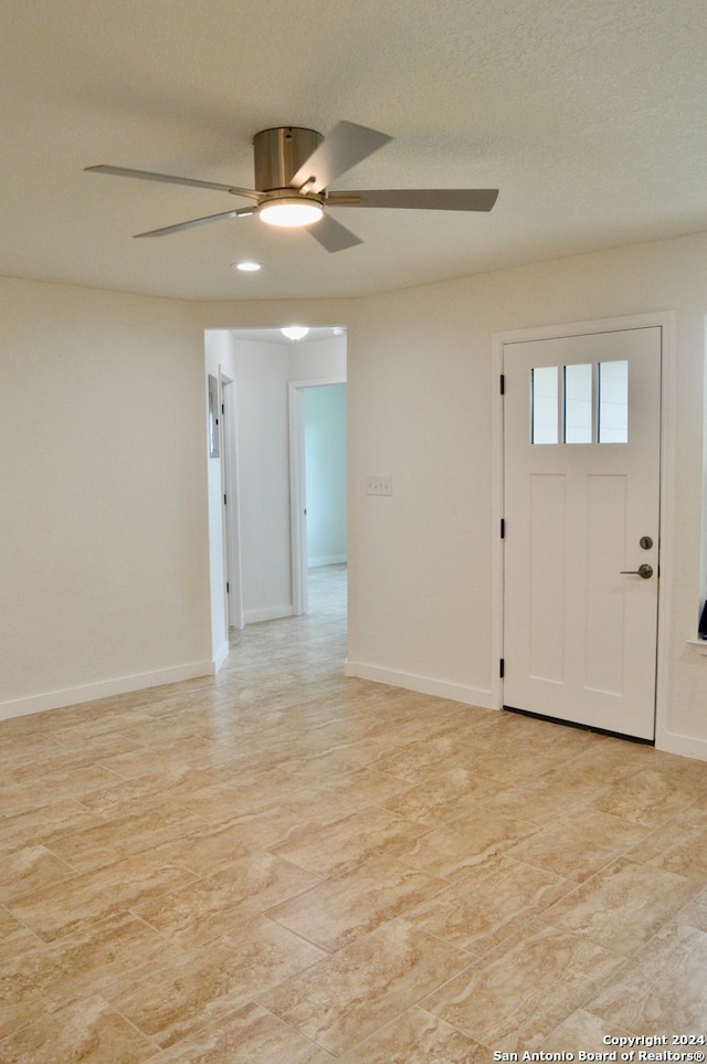 foyer entrance featuring ceiling fan and a textured ceiling