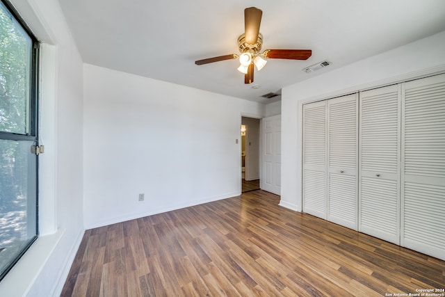 unfurnished bedroom with dark hardwood / wood-style flooring, ceiling fan, and a closet