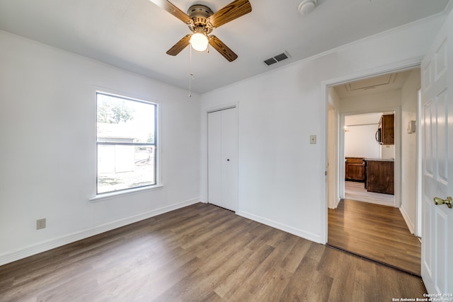 unfurnished bedroom featuring hardwood / wood-style flooring, ceiling fan, and a closet