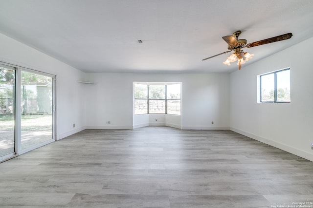 unfurnished room with a healthy amount of sunlight, ceiling fan, and light hardwood / wood-style floors