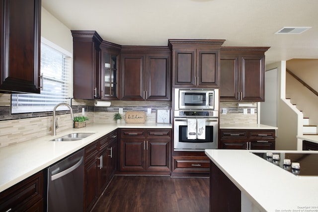 kitchen with decorative backsplash, sink, dark hardwood / wood-style floors, dark brown cabinets, and appliances with stainless steel finishes