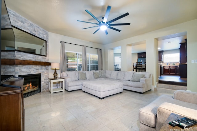 living room featuring a fireplace and ceiling fan