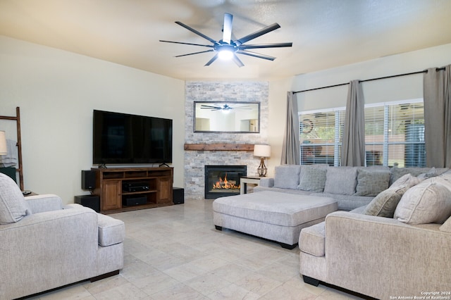 living room featuring a stone fireplace and ceiling fan