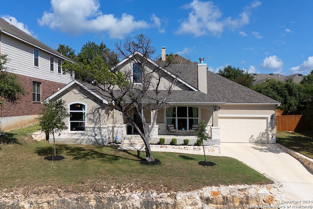 view of front of house with covered porch, a front yard, and a garage