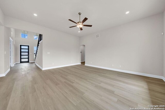 unfurnished living room with ceiling fan and light hardwood / wood-style floors