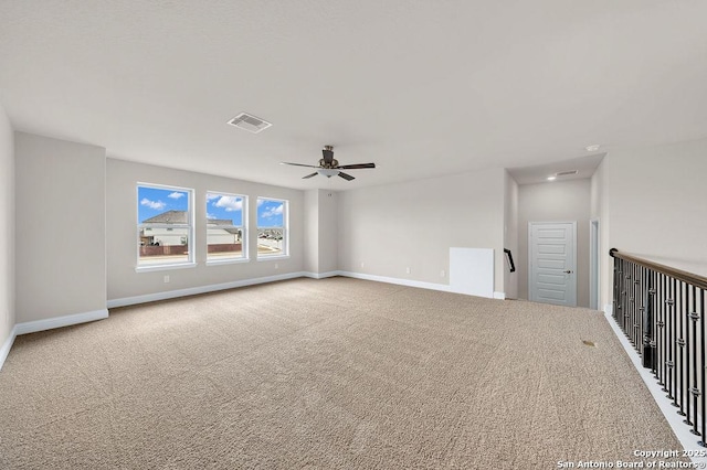 unfurnished room with ceiling fan and carpet