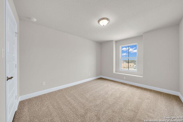 carpeted empty room with a textured ceiling