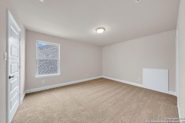 unfurnished room featuring carpet flooring and a textured ceiling