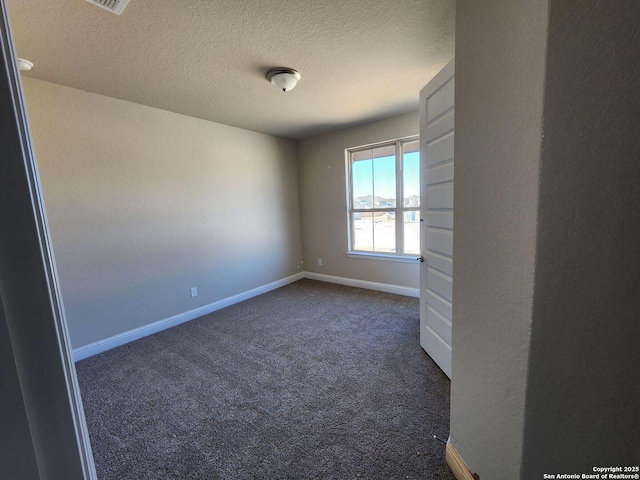 carpeted empty room featuring a textured ceiling