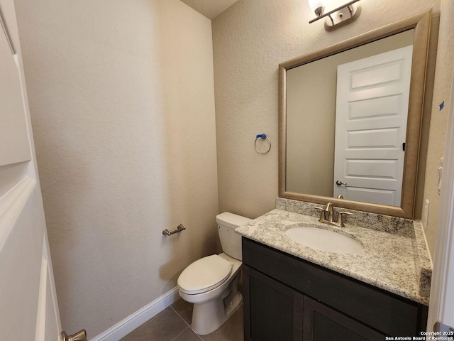 bathroom featuring vanity, tile patterned floors, and toilet