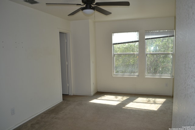 carpeted spare room featuring ceiling fan