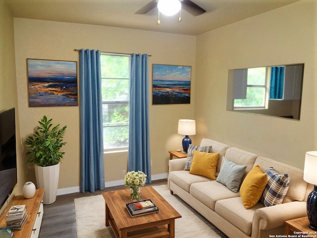 living room featuring baseboards, a ceiling fan, and wood finished floors