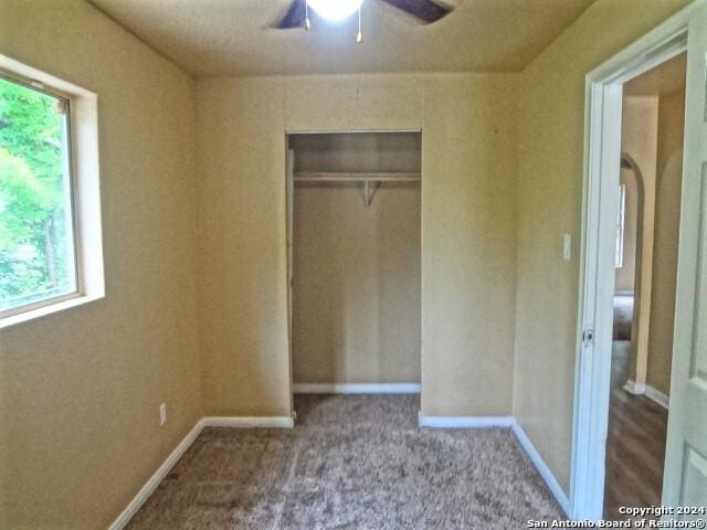 unfurnished bedroom featuring a closet, carpet flooring, ceiling fan, and baseboards