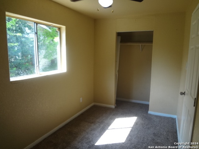 unfurnished bedroom featuring carpet, a closet, and ceiling fan