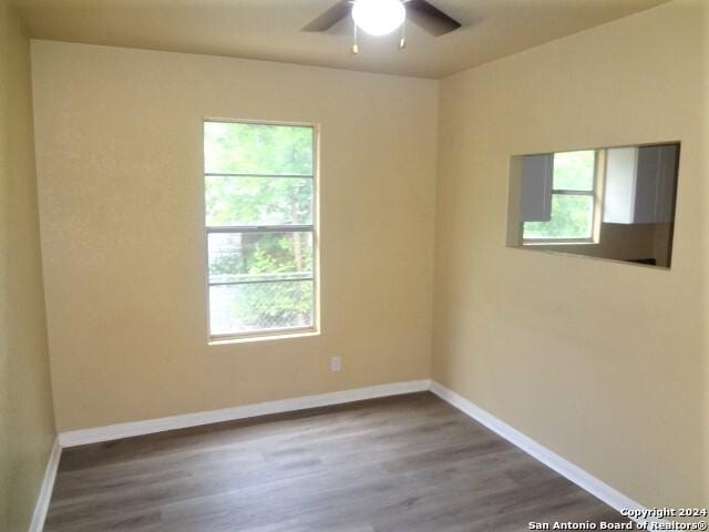 empty room with wood finished floors, baseboards, and ceiling fan