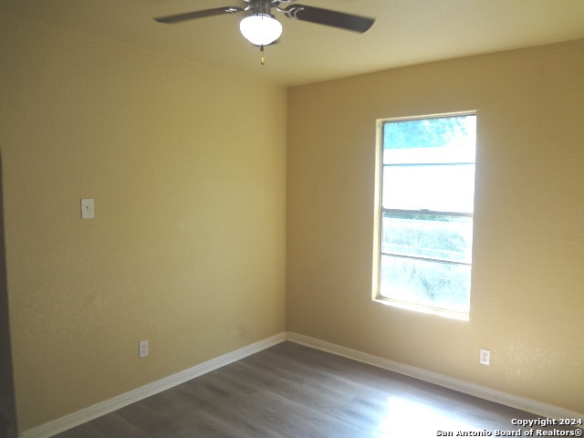 empty room with ceiling fan and hardwood / wood-style flooring