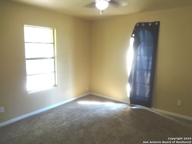 carpeted empty room featuring ceiling fan