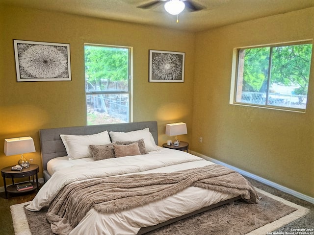 bedroom with baseboards, multiple windows, and ceiling fan