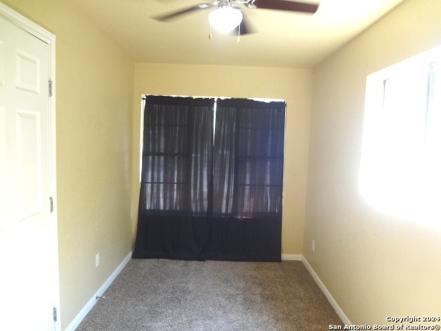 unfurnished room featuring ceiling fan and carpet