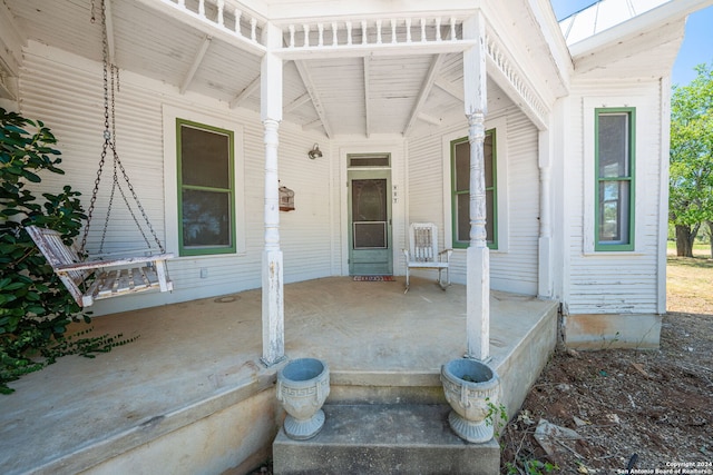 view of exterior entry featuring covered porch