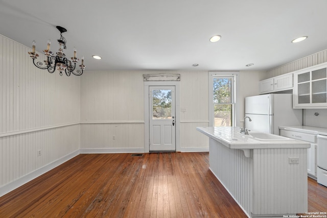 kitchen with white appliances, white cabinetry, a center island with sink, and dark hardwood / wood-style floors