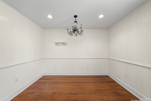 unfurnished room with dark hardwood / wood-style floors and an inviting chandelier