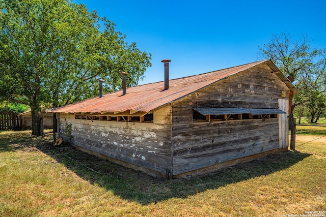 view of side of home featuring an outbuilding and a yard